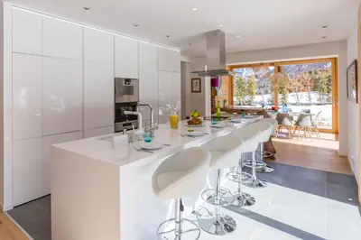 a kitchen with a large white island with bar stools at Chalet Montana- Chamonix All Year in Chamonix-Mont-Blanc