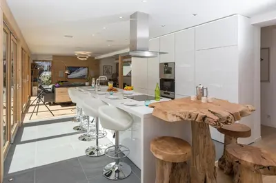 a kitchen with a long bar with stools at Chalet Montana- Chamonix All Year in Chamonix-Mont-Blanc