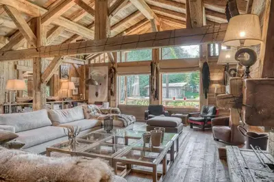 a living room with a couch and a table at Chalet Javen - 520m2 avec piscine chauffée et home cinéma in Megève