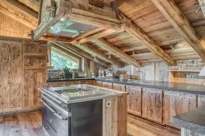 a kitchen with wooden walls and a wooden ceiling at Chalet Javen - 520m2 avec piscine chauffée et home cinéma in Megève