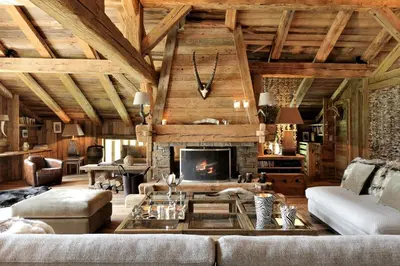 a living room with a couch and a fireplace at Chalet Javen - 520m2 avec piscine chauffée et home cinéma in Megève
