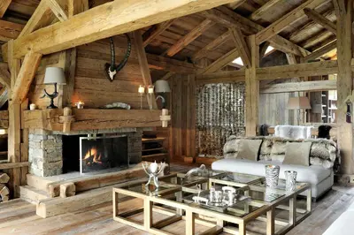 a living room with a fireplace and a couch at Chalet Javen - 520m2 avec piscine chauffée et home cinéma in Megève