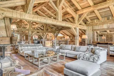 a living room filled with furniture and a wooden ceiling at Chalet Javen - 520m2 avec piscine chauffée et home cinéma in Megève