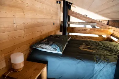 a bed in a cabin with a wooden wall at Chalet Victoire in Chamonix-Mont-Blanc