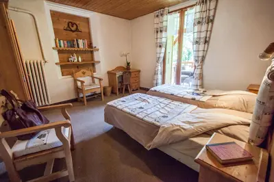 a bedroom with two beds and a window at Résidence La Cour in Samoëns