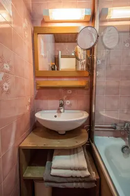 a bathroom with a sink and a mirror and a tub at Résidence La Cour in Samoëns