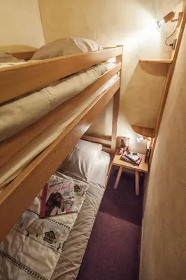 two bunk beds in a room with a table at Résidence La Cour in Samoëns