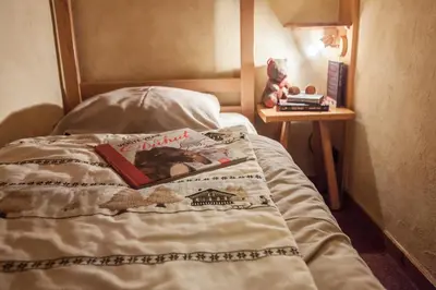 a book sitting on top of a bed at Résidence La Cour in Samoëns