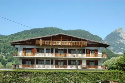 a large building with wooden balconies on a mountain at Appartements Giffre et Clesson - DAHU COMPAGNIE in Samoëns
