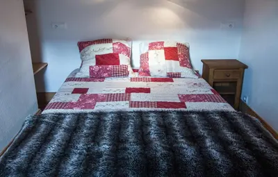 a bedroom with a bed with a quilt on it at Appartements Giffre et Clesson - DAHU COMPAGNIE in Samoëns