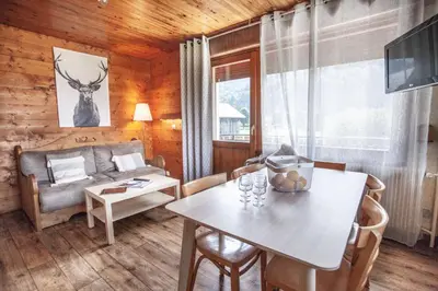 a living room with a table and a couch at Appartements Giffre et Clesson - DAHU COMPAGNIE in Samoëns