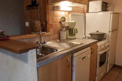 a kitchen with a sink and a refrigerator at Appartements Giffre et Clesson - DAHU COMPAGNIE in Samoëns