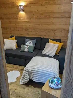 a living room with a blue couch with pillows at Chalet des glaciers in Chamonix-Mont-Blanc