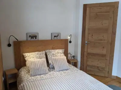 a bedroom with a bed with two pillows and a door at Chalet des glaciers in Chamonix-Mont-Blanc