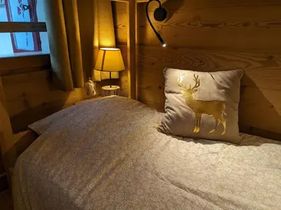 a bedroom with a bed with a deer pillow and a lamp at Chalet des glaciers in Chamonix-Mont-Blanc