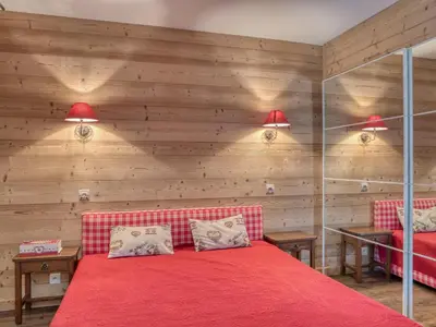 a bedroom with a red bed and wooden walls at Appartement confort 2 pièces Megève - Wifi, Parking - FR-1-453-125 in Megève