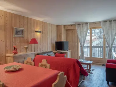 a bedroom with a bed and a table and a television at Appartement confort 2 pièces Megève - Wifi, Parking - FR-1-453-125 in Megève