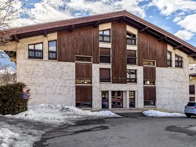 an apartment building with a wooden facade with a parking lot at Appartement confort 2 pièces Megève - Wifi, Parking - FR-1-453-125 in Megève