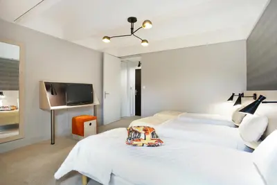 a bedroom with two beds and a flat screen tv at Hôtel Club MMV Le Flaine in Flaine
