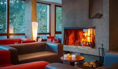 a living room with a fireplace and couches at Hôtel Club MMV Le Flaine in Flaine