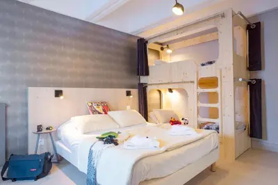 a bedroom with a large white bed and bunk beds at Hôtel Club MMV Le Flaine in Flaine