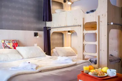 a bedroom with two bunk beds and a tray of food at Hôtel Club MMV Le Flaine in Flaine