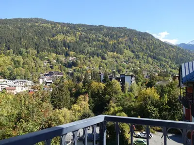 a red couch in a room with a large window at Apartment Le Grand Panorama 412 by Interhome in Saint-Gervais-les-Bains