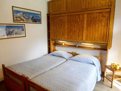 a bedroom with a bed with a wooden headboard at Apartment Les Jardins du Mont-Blanc-5 by Interhome in Chamonix-Mont-Blanc