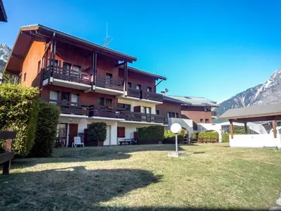 a large apartment building with a yard in front of it at Apartment Les Jardins du Mont-Blanc-5 by Interhome in Chamonix-Mont-Blanc