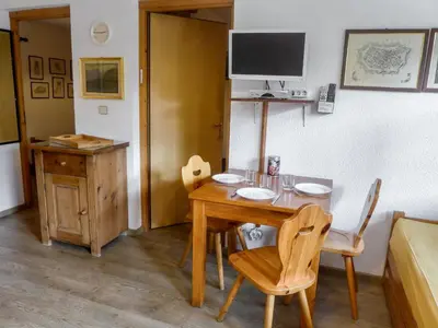 a dining room with a table and chairs and a television at Apartment Les Jardins du Mont-Blanc-5 by Interhome in Chamonix-Mont-Blanc