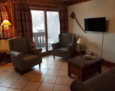 a living room with two chairs and a tv at La Ginabelle Gala in Chamonix-Mont-Blanc