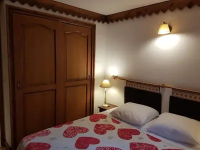 a bedroom with a bed with a red and white bedspread at La Ginabelle Gala in Chamonix-Mont-Blanc