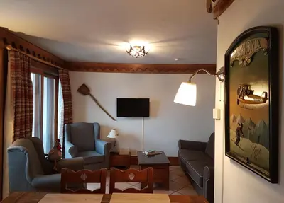 a living room with two chairs and a tv at La Ginabelle Gala in Chamonix-Mont-Blanc