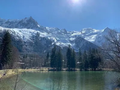 a lake with snow covered mountains in the background at Hotel des Lacs in Chamonix-Mont-Blanc