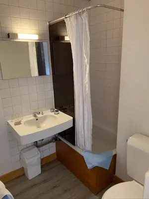 a bathroom with a sink and a shower curtain at Hotel des Lacs in Chamonix-Mont-Blanc