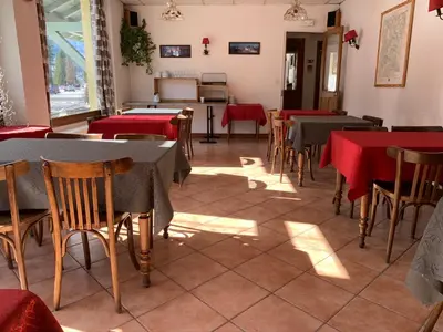 a restaurant with tables and chairs with red tablecloths at Hotel des Lacs in Chamonix-Mont-Blanc