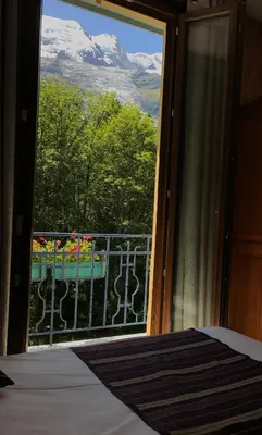 a bedroom with a window with a view of a mountain at Hotel des Lacs in Chamonix-Mont-Blanc
