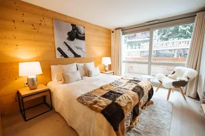a bedroom with a bed and a large window at Residence Lesporting Ski – Appartment – АЕ103 in Megève