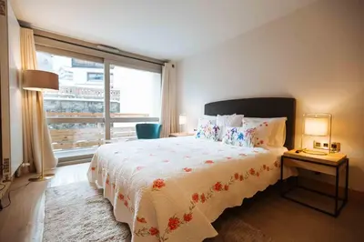 a bedroom with a bed and a large window at Residence Lesporting Ski – Appartment – АЕ103 in Megève