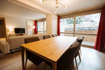 a living room with a wooden table and a bedroom at Residence Lesporting Ski – Appartment – АЕ103 in Megève