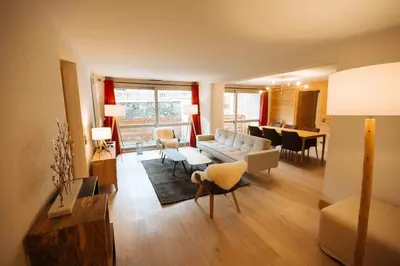 a living room with a couch and a dining room at Residence Lesporting Ski – Appartment – АЕ103 in Megève