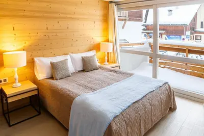 a bedroom with a bed and a large window at Fantastic tenement Megève - AE 101 in Megève