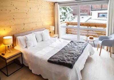 a bedroom with a bed and a large window at Fantastic tenement Megève - AE 101 in Megève