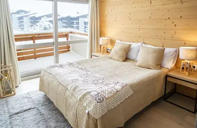 a bedroom with a bed and a large window at Winter Vacances - Megève excellent apartment - AE 301 in Megève