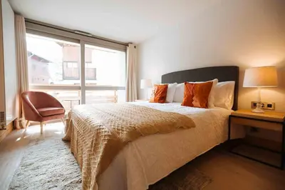 a bedroom with a bed with a desk and a window at Megève Great apartment Lesporting Ski - AE 303 in Megève