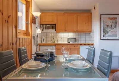 a kitchen with a table with plates and wine glasses at Alpage: Residence Brevent in Les Houches