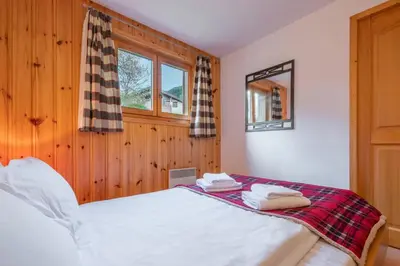 a bedroom with a bed and a window at Alpage: Residence Brevent in Les Houches
