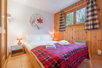 a bedroom with a bed with a plaid blanket at Alpage: Residence Brevent in Les Houches