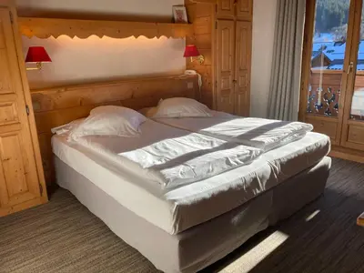 a large bed in a room with a window at Oustalet in Chamonix-Mont-Blanc