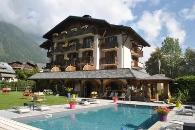 a large building with a swimming pool in front of it at Oustalet in Chamonix-Mont-Blanc
